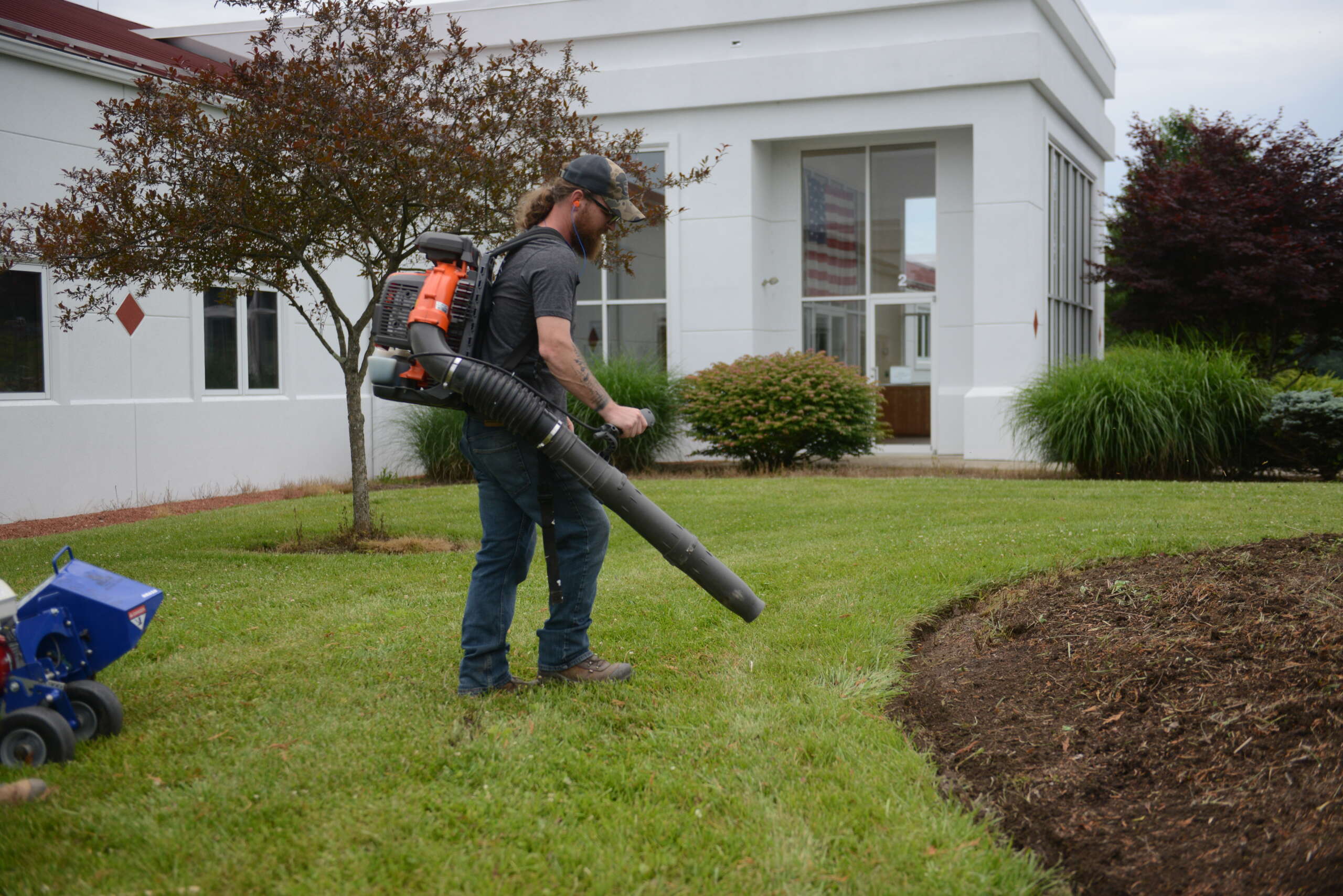 Bear Rental employee uses a leaf blower to clean up.